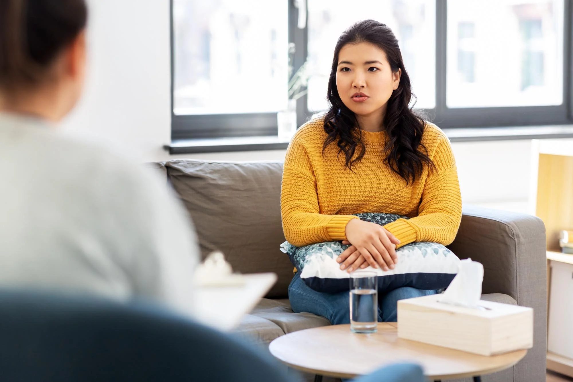 Autistic woman sits across from therapist doing autism affirming therapy at Tangible Therapy in Orem Utah
