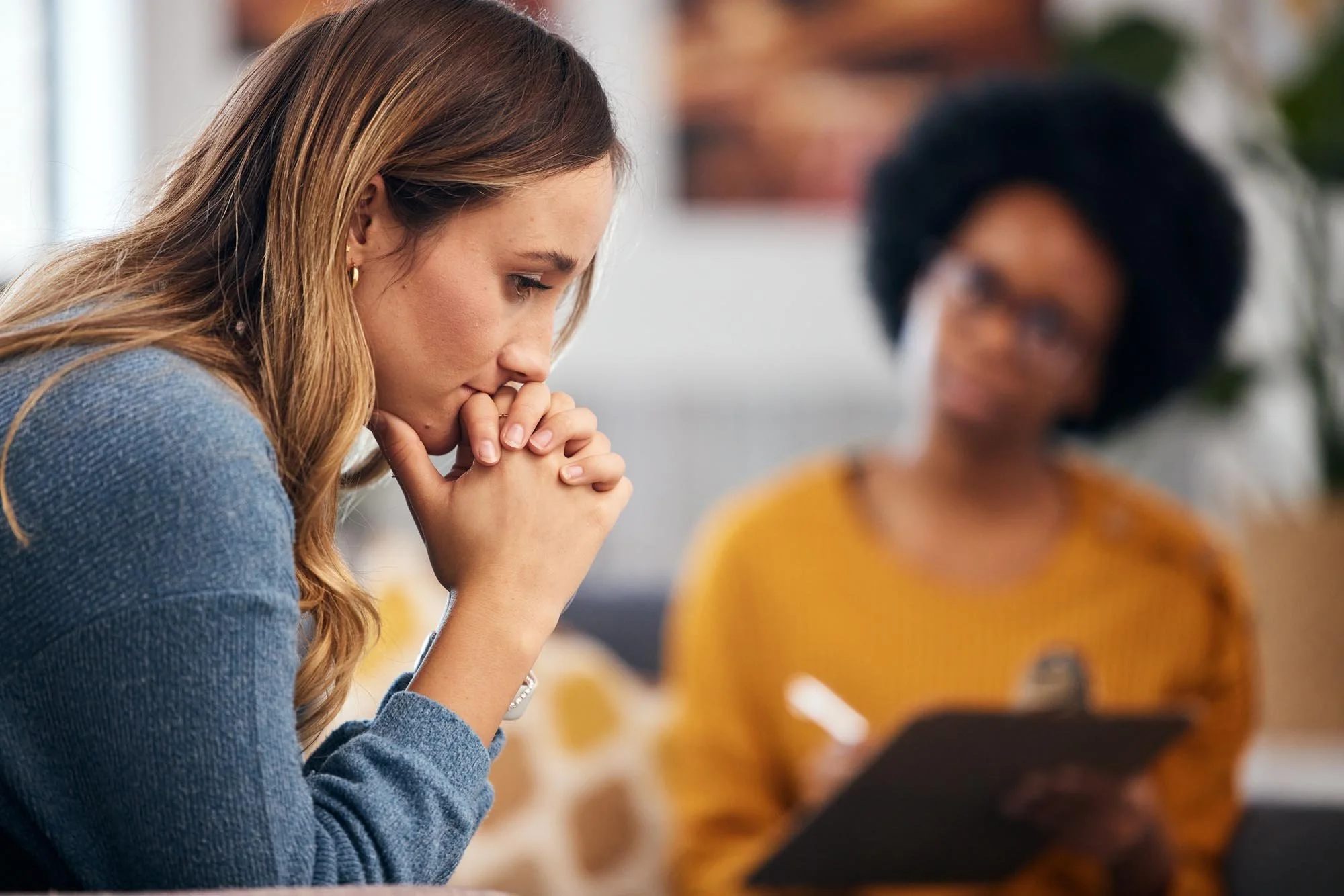 Woman sits anxiously across from black female therapist at Tangible Therapy in Orem