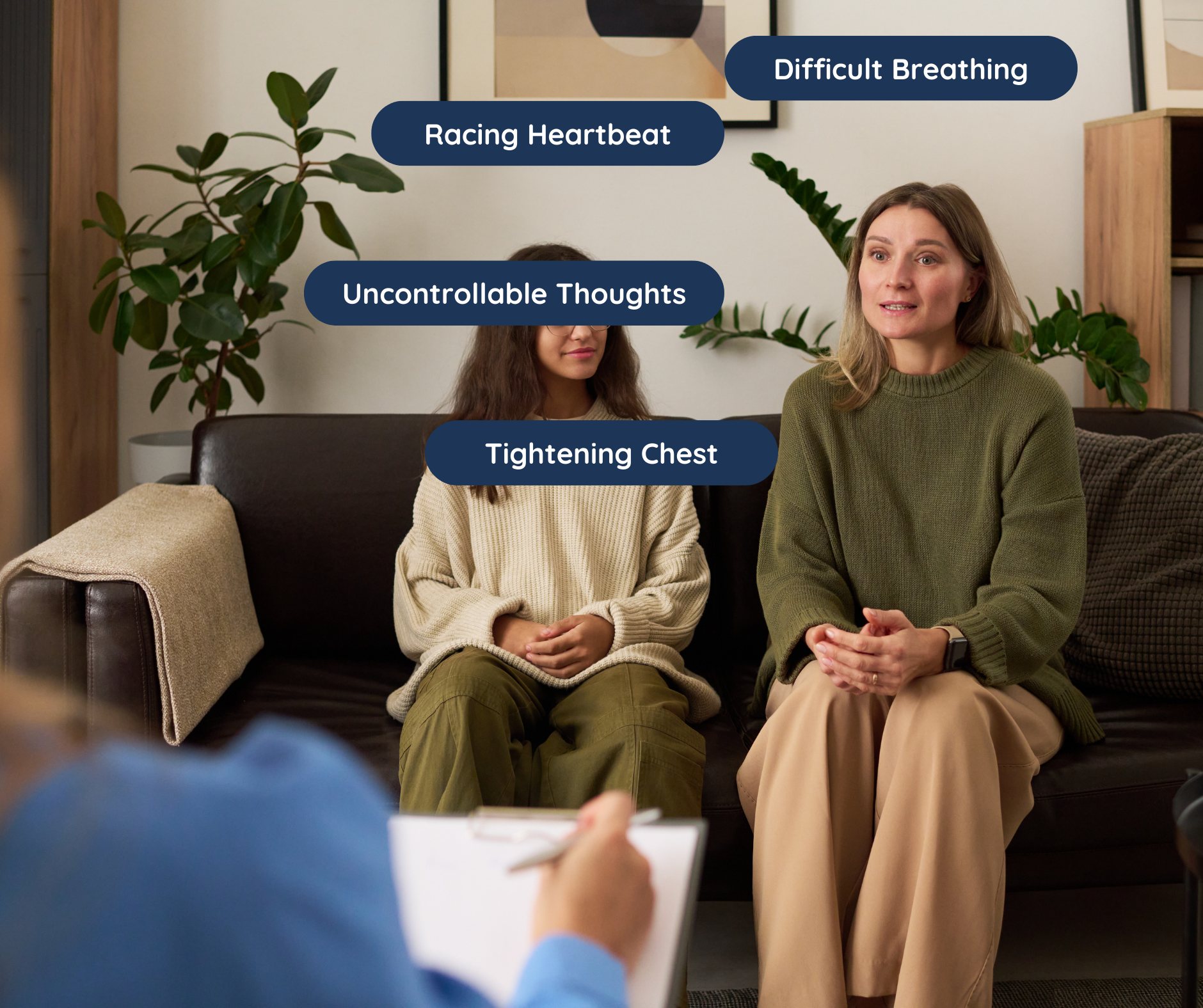 Two women sitting on a brown couch during a therapy session, with labels pointing to their feelings and physical states: one woman with a tight chest and uncontrollable thoughts, the other with difficult breathing and racing heartbeat.